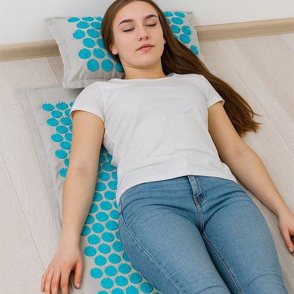 femme en teeshirt blanc sur tapis d'acupression sur plancher de bois gris