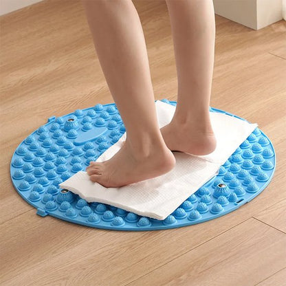 pieds sur serviette sur tapis d'acupression sur plancher de bois