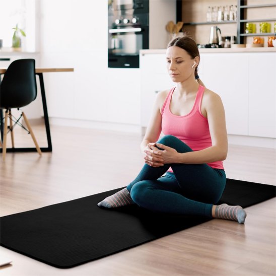 femme sur tapis de yoga dans la salle a manger